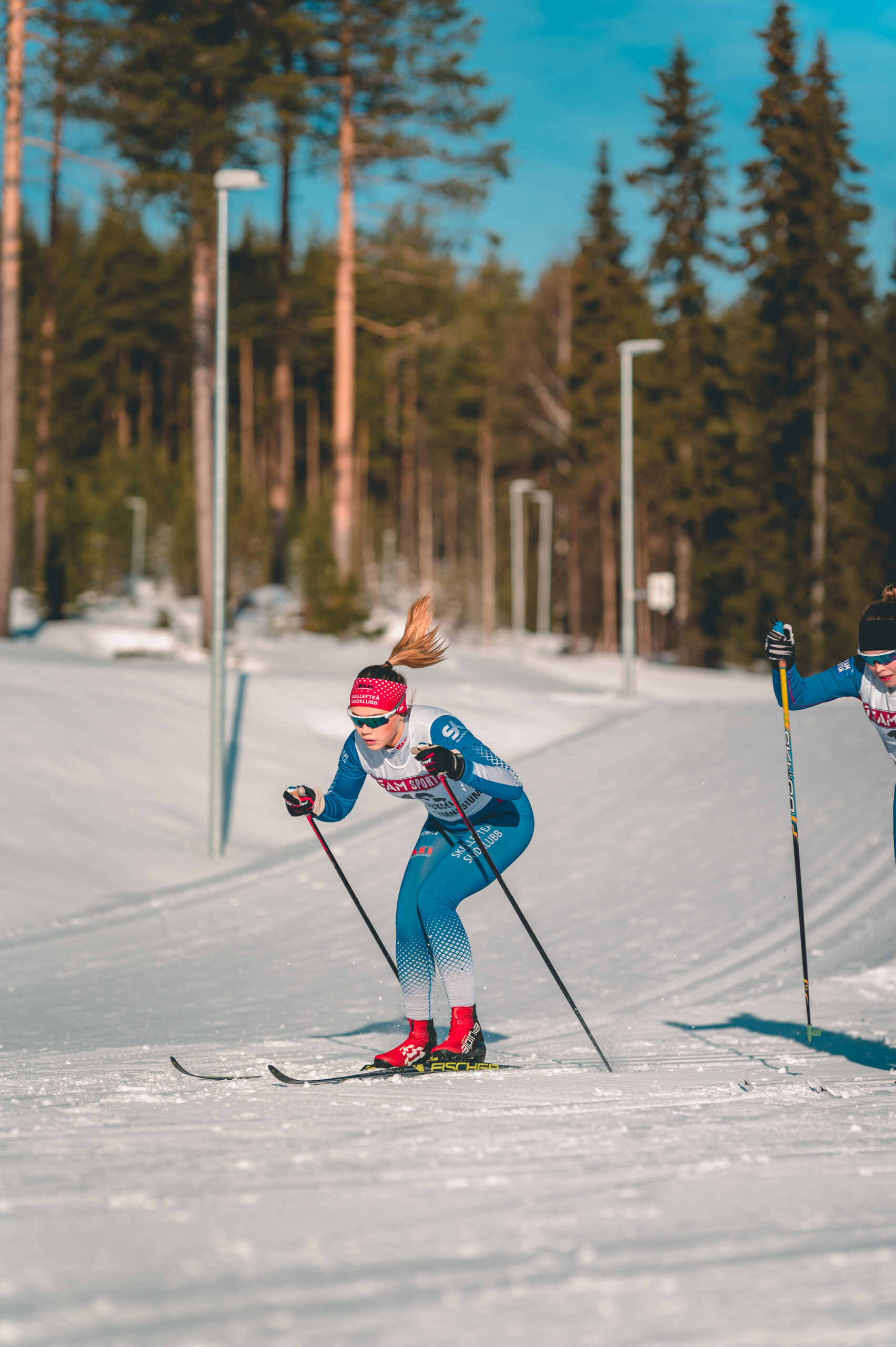 Bilden föreställer en ung tjej som åker skidor.